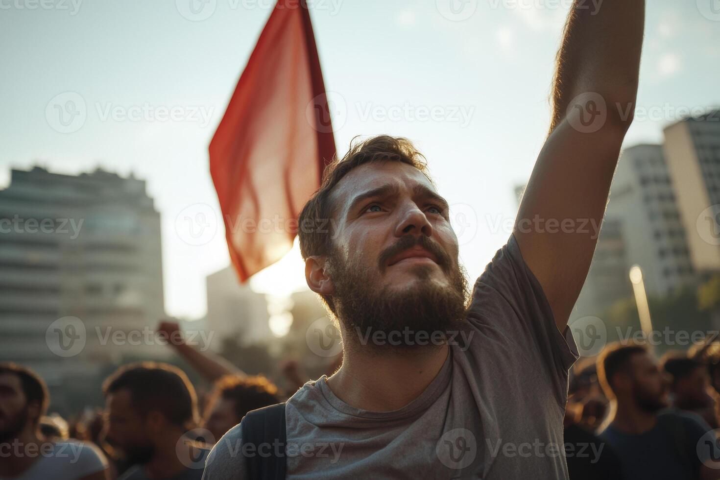 Man raises a flag in support during a protest in an urban setting against social issues, reflecting collective activism and solidarity photo