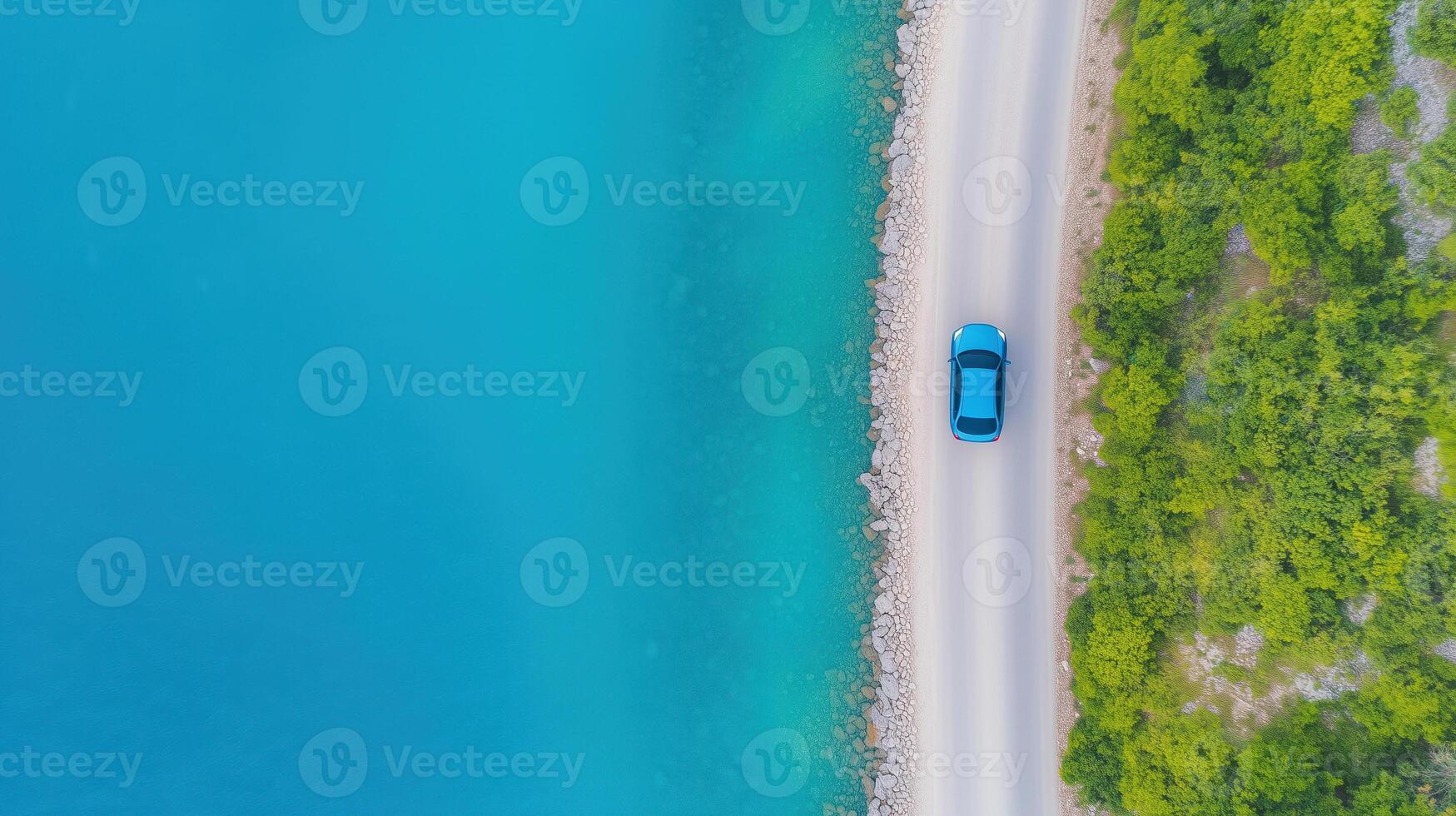 Aerial View of Vibrant Blue Car on Scenic Coastal Road by Pristine Mediterranean Waters and Lush Greenery photo