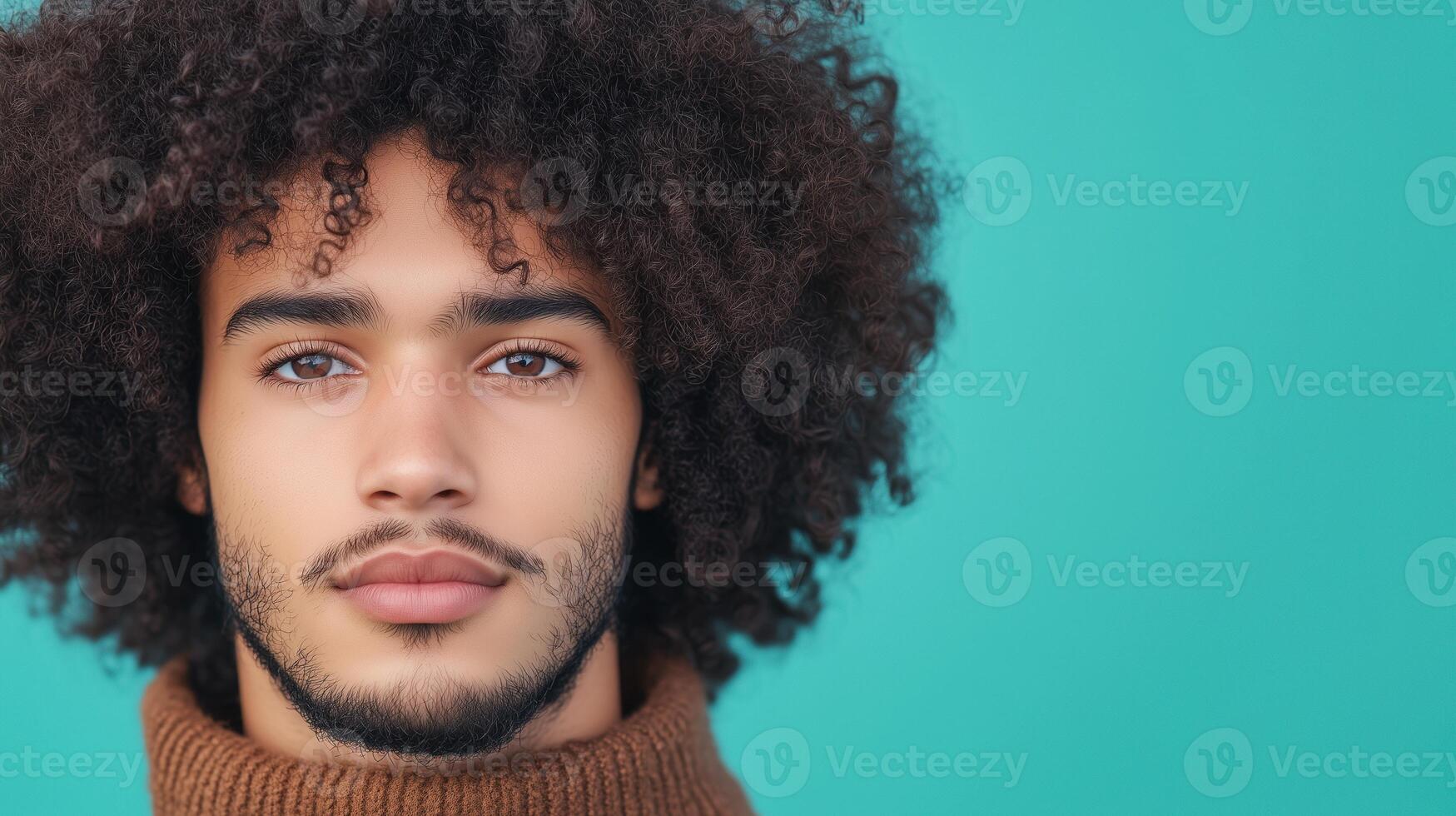 Portrait of Young Man with Curly Hair in Brown Sweater Against Turquoise Background Emphasizing Serenity and Confidence in Modern Stock Photography for Contemporary Design Projects photo