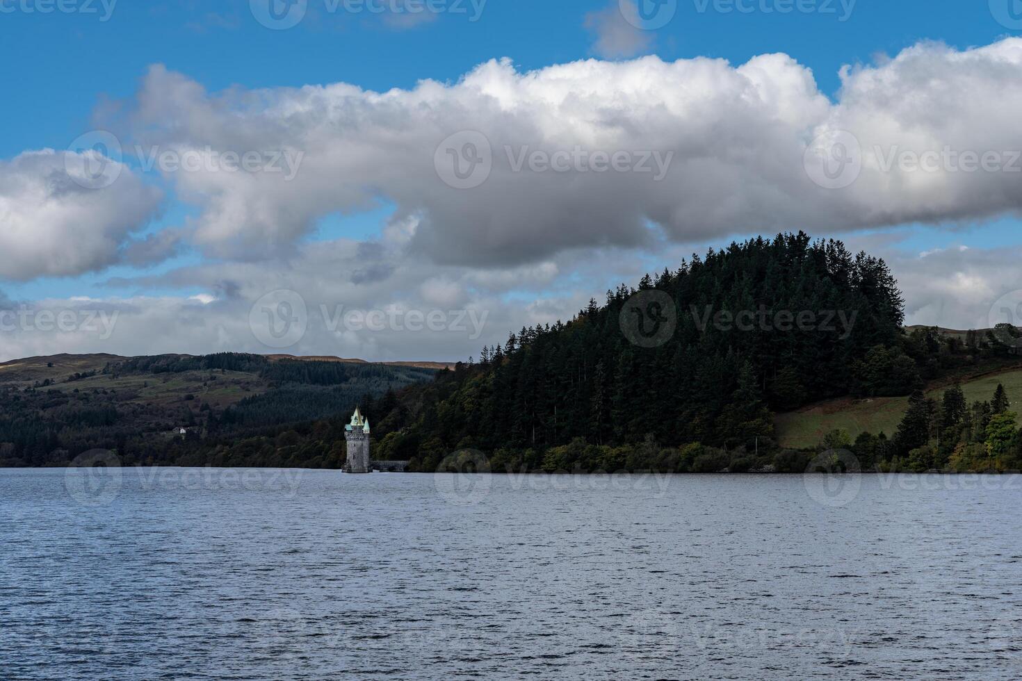 Llyn vyrnwy dam and reservoir reflecting autumn colors under cloudy sky photo