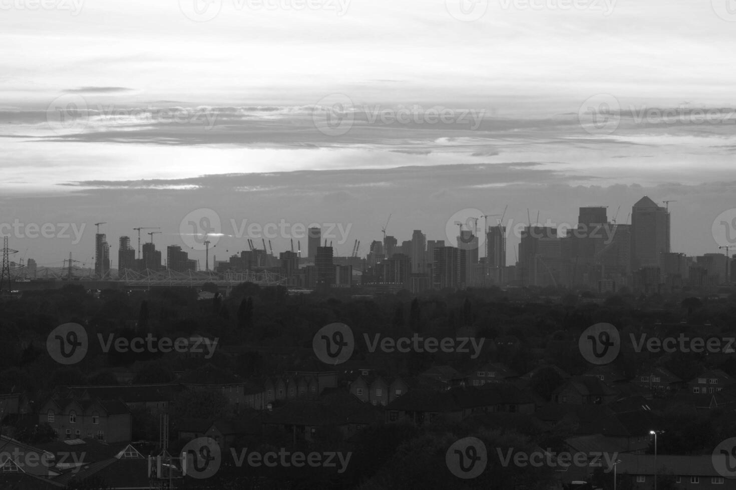 Canary Wharf emerging from the suburbs at sunset in black and white photo