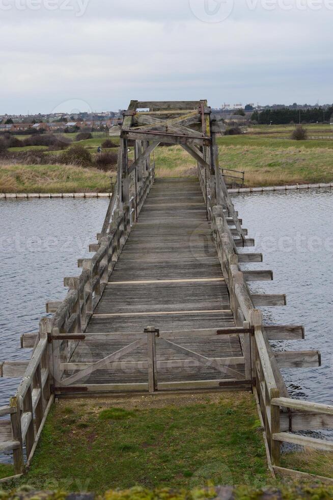 Old wooden bridge crossing a river in Great Britain photo