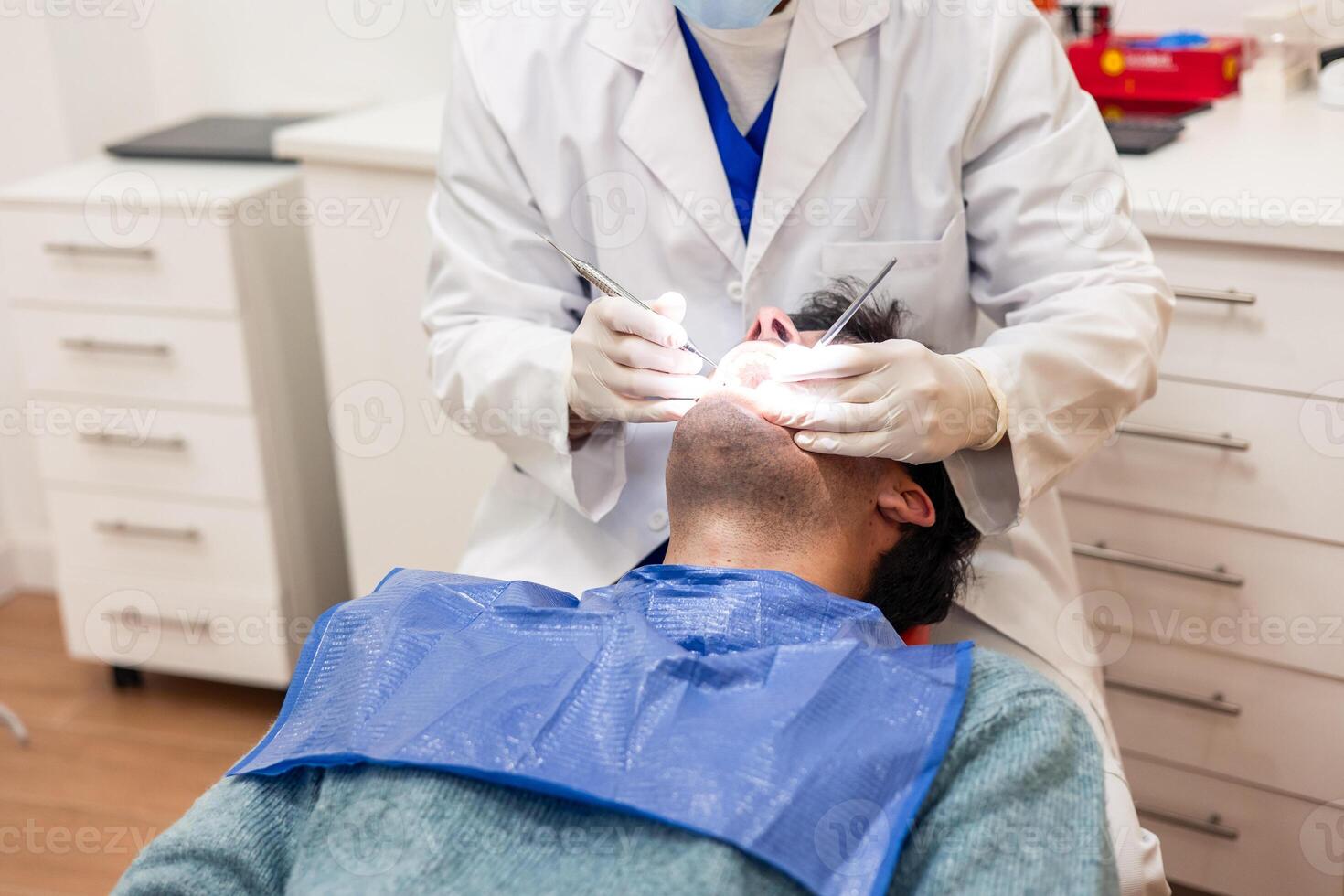 Dentist performing dental checkup on patient in dental clinic photo