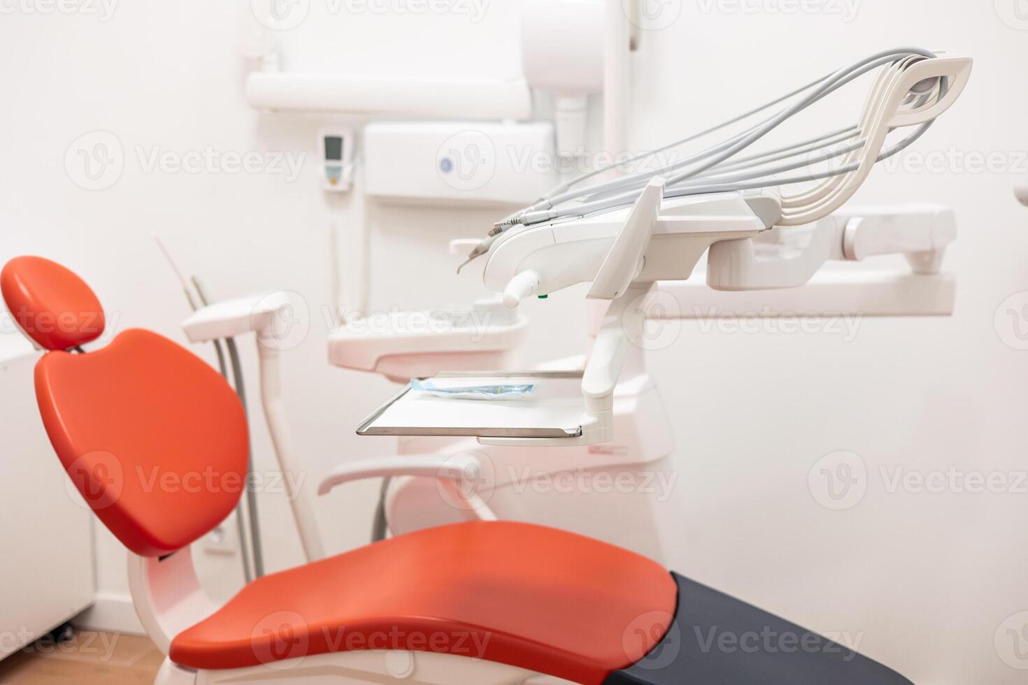 Modern red dentist chair stands in empty office photo