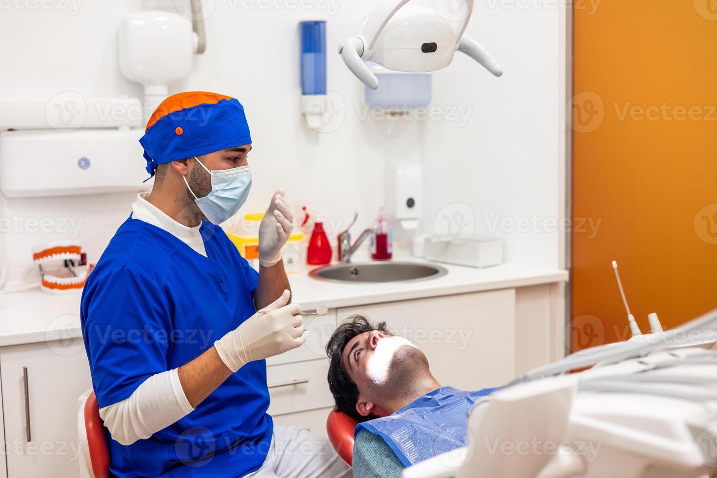 Dentist preparing tools for operating patient in dental clinic photo