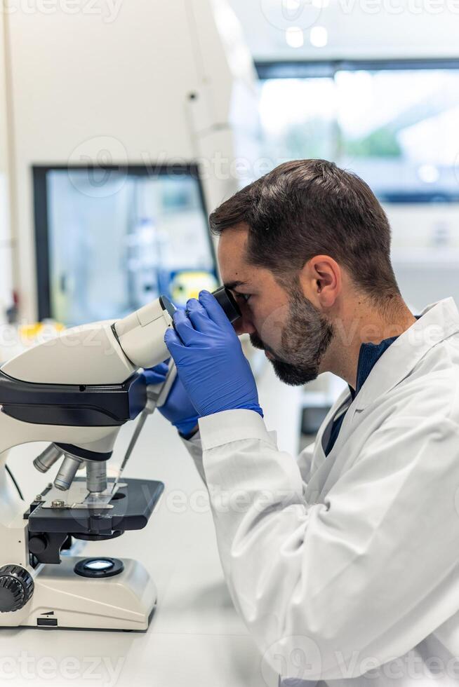 Scientist using microscope in laboratory doing scientific research photo
