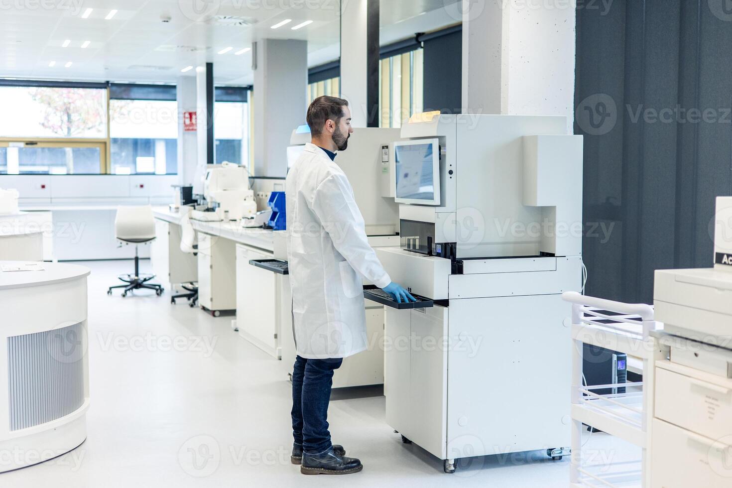 Scientist working with modern automated equipment in laboratory photo