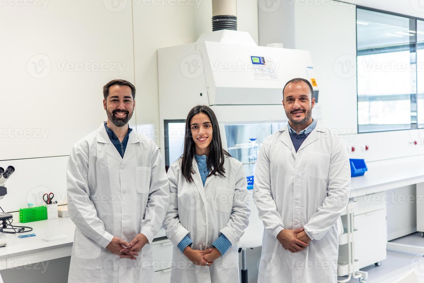 Scientists smiling in laboratory wearing lab coats photo