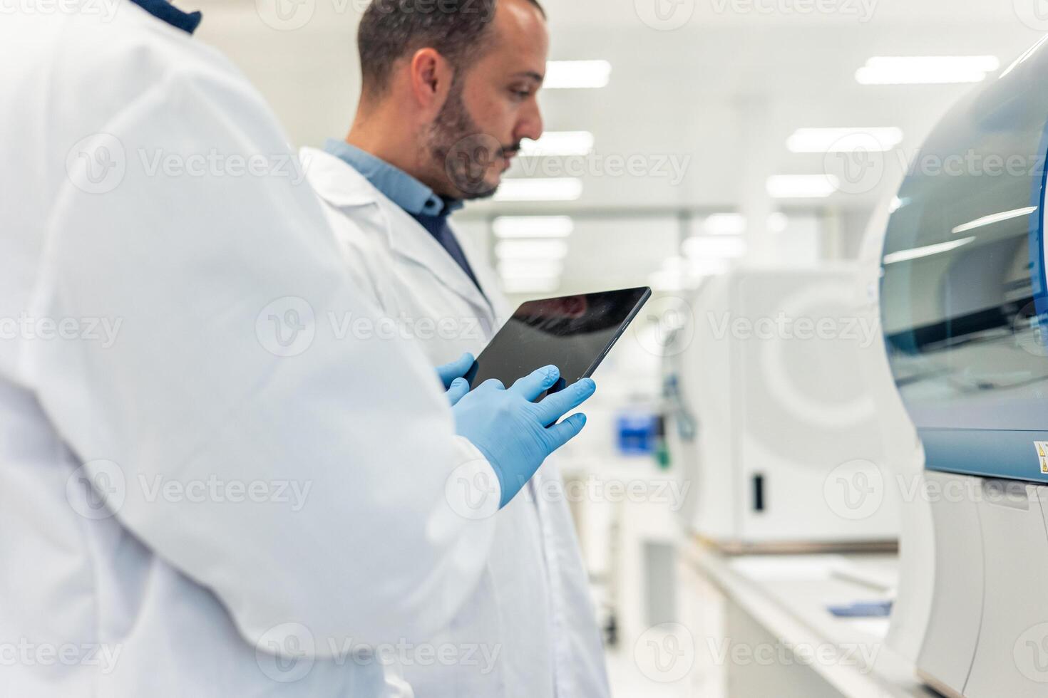 Scientists using tablet and working in modern laboratory photo