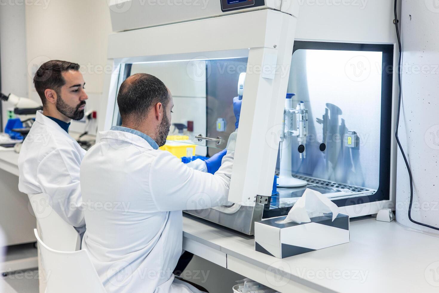 two Scientists working with advanced equipment in modern bio laboratory photo