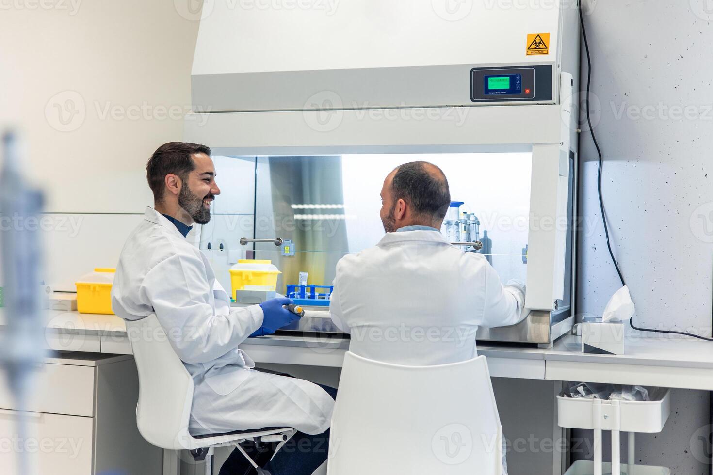 Two male scientists smiling and working together in modern laboratory photo