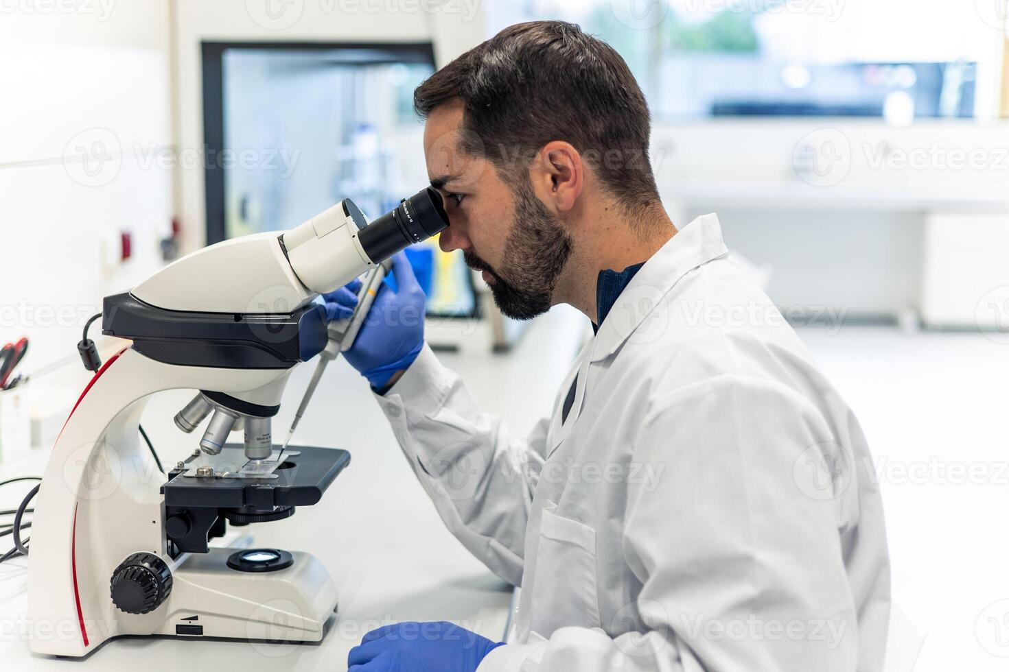 Scientist using a microscope in modern laboratory performing scientific research photo