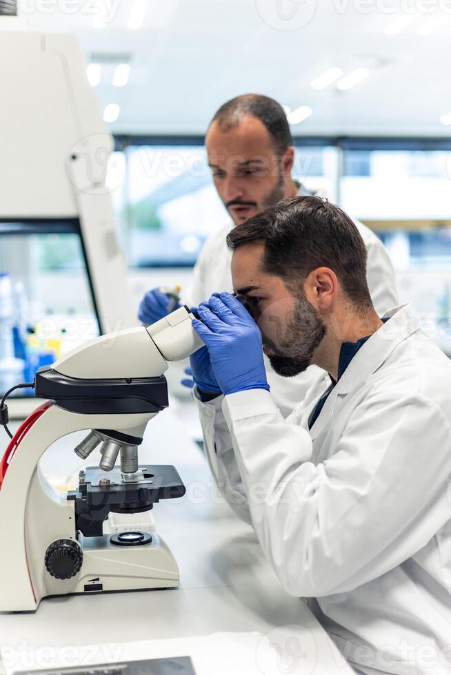 Scientists working with microscope in laboratory doing research photo