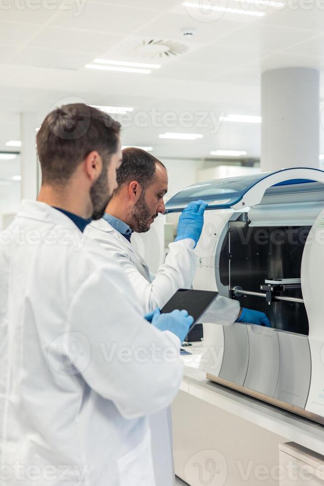 Scientists working with modern equipment in laboratory photo
