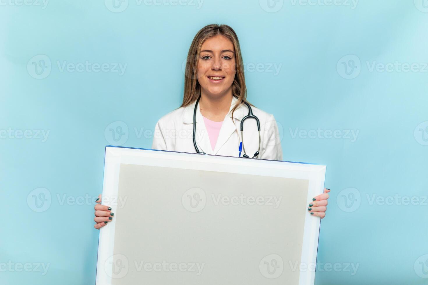 Smiling doctor woman showing blank x-ray on blue background photo