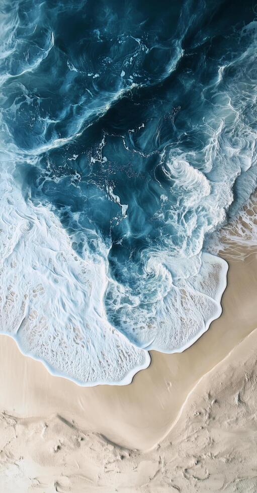 Waves crashing on sandy beach with vibrant turquoise water and gentle foam at shoreline photo
