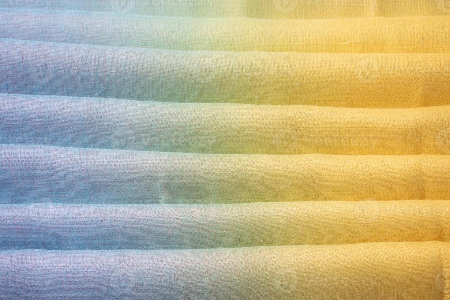 colorful folded fabric background texture. blue yellow and green. photo