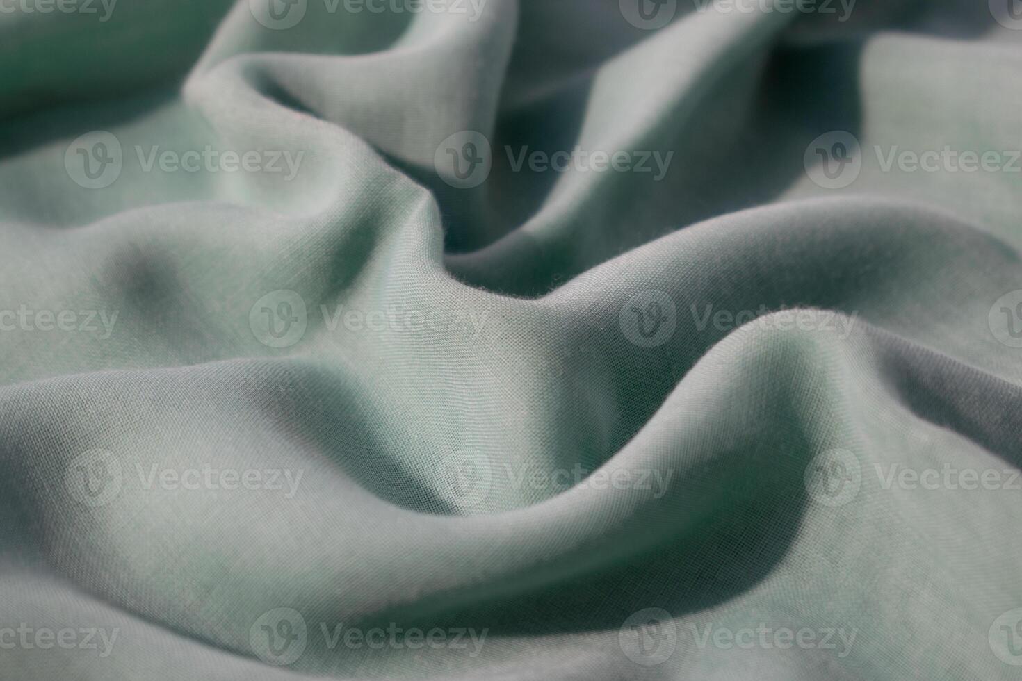 close up Nude green fabric wavy crumpled background texture with copy space. photo
