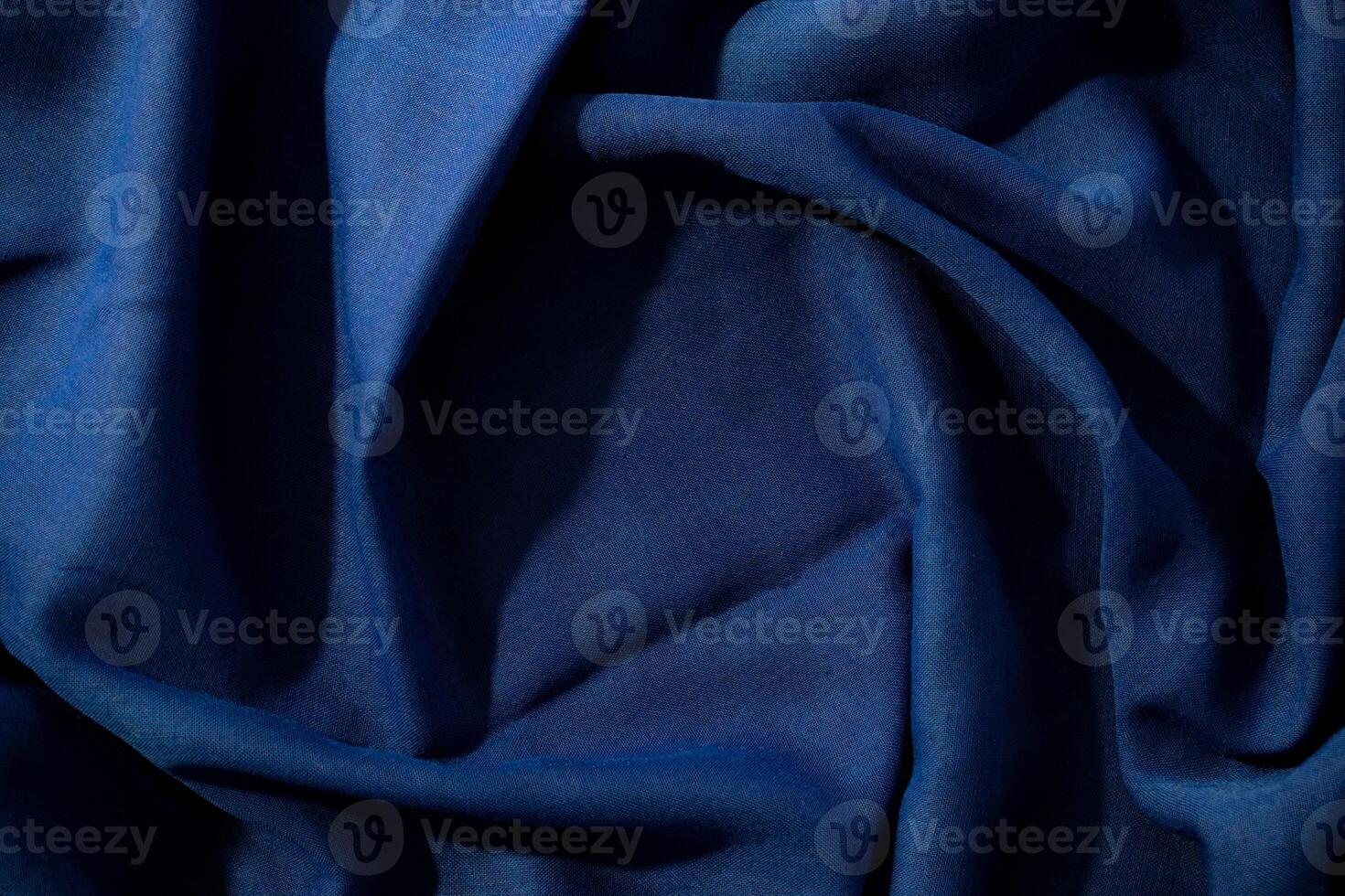 wavy spiral crumpled background texture Navy or dark blue fabric with copy space in the center. photo