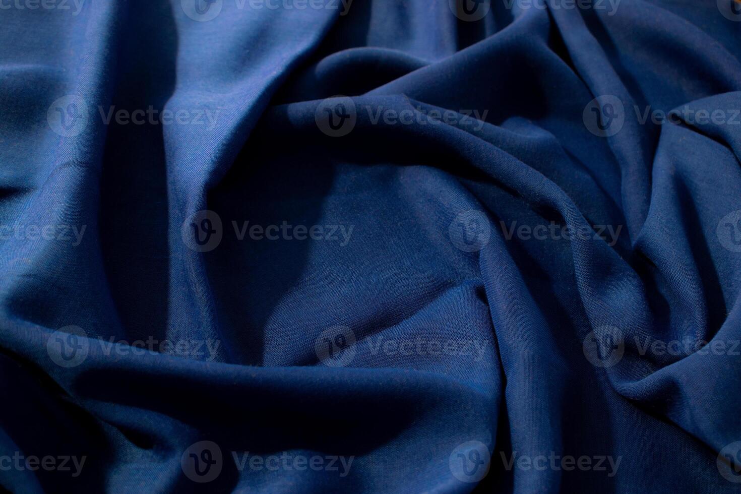 wavy spiral crumpled Navy or dark blue fabric background texture with copy space in the center. photo