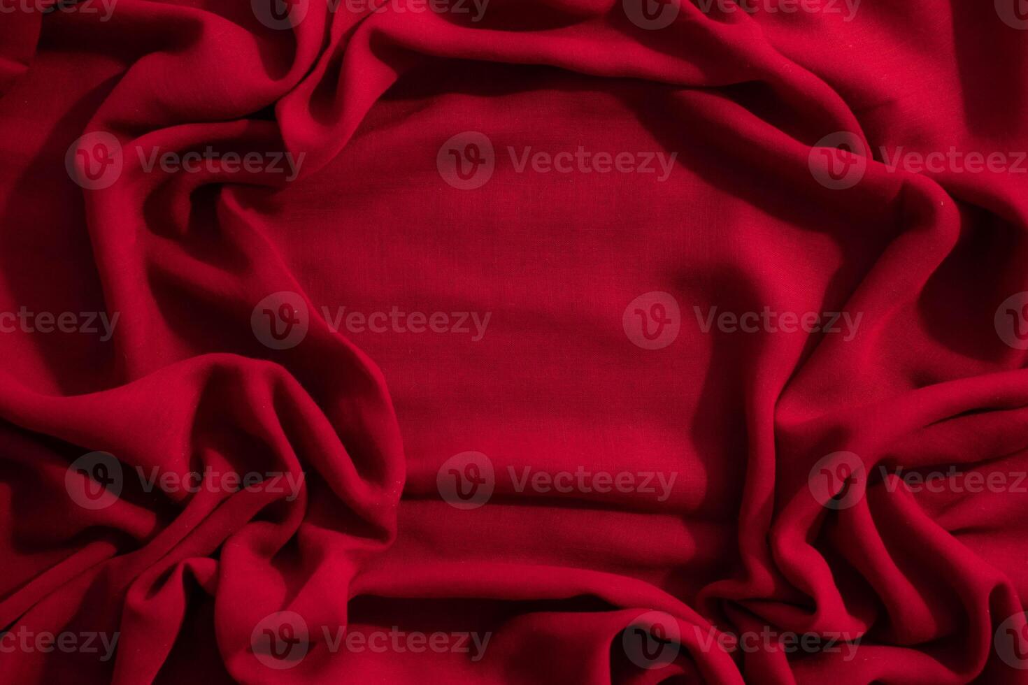 Red fabric wavy crumpled abstract background texture with copy space. photo