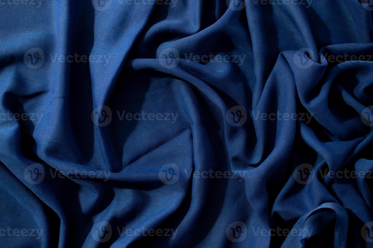 abstract background texture Navy or dark blue fabric wavy spiral crumpled with copy space in the center. photo