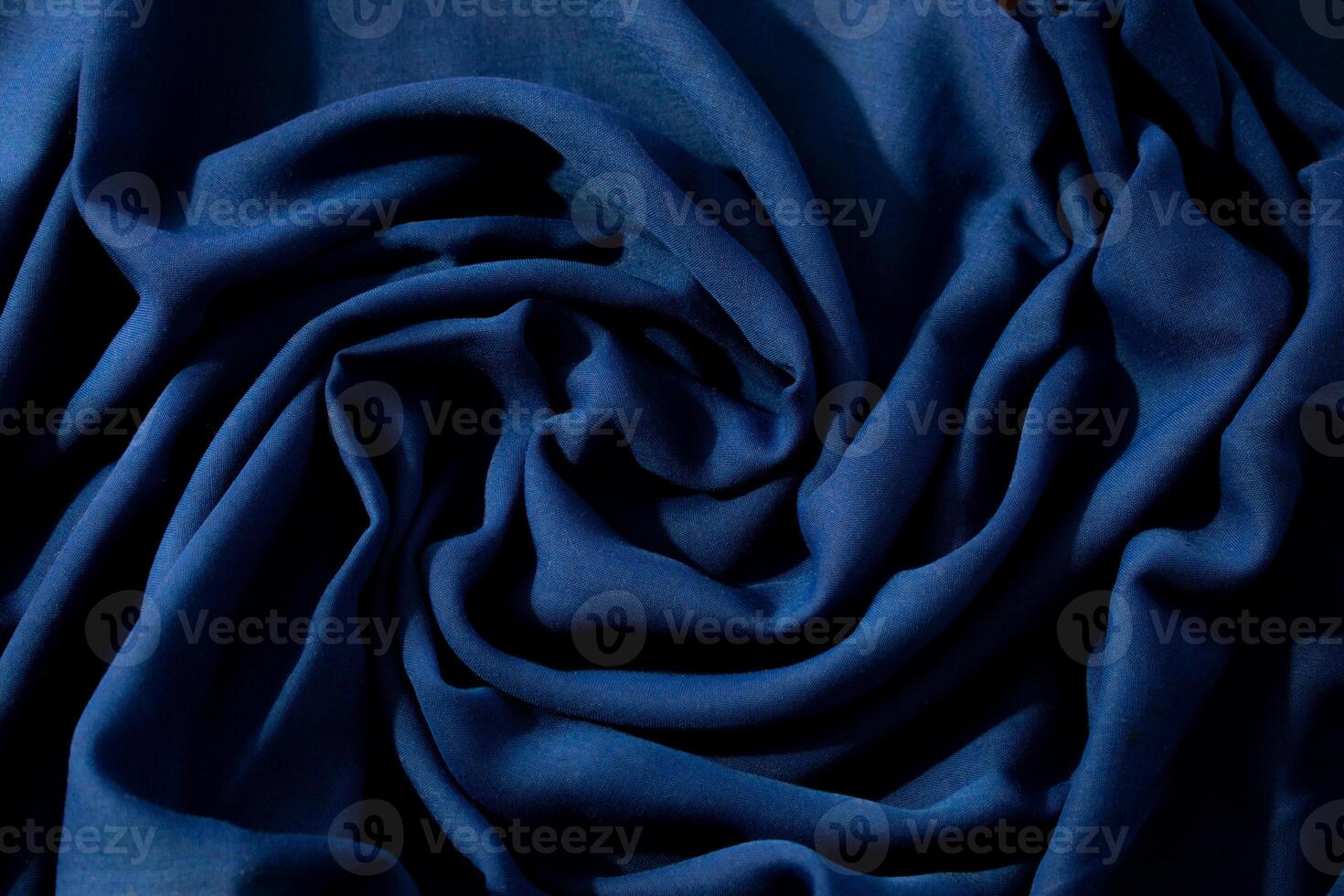 Navy or dark blue fabric wavy spiral crumpled background texture. photo