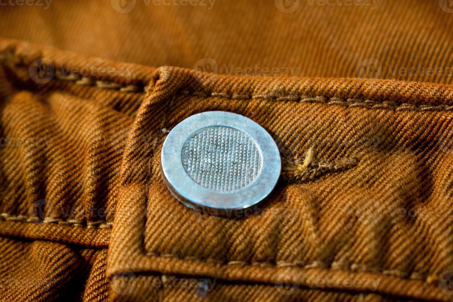 Metallic button on bright brown jeans fabric, background texture mockup photo