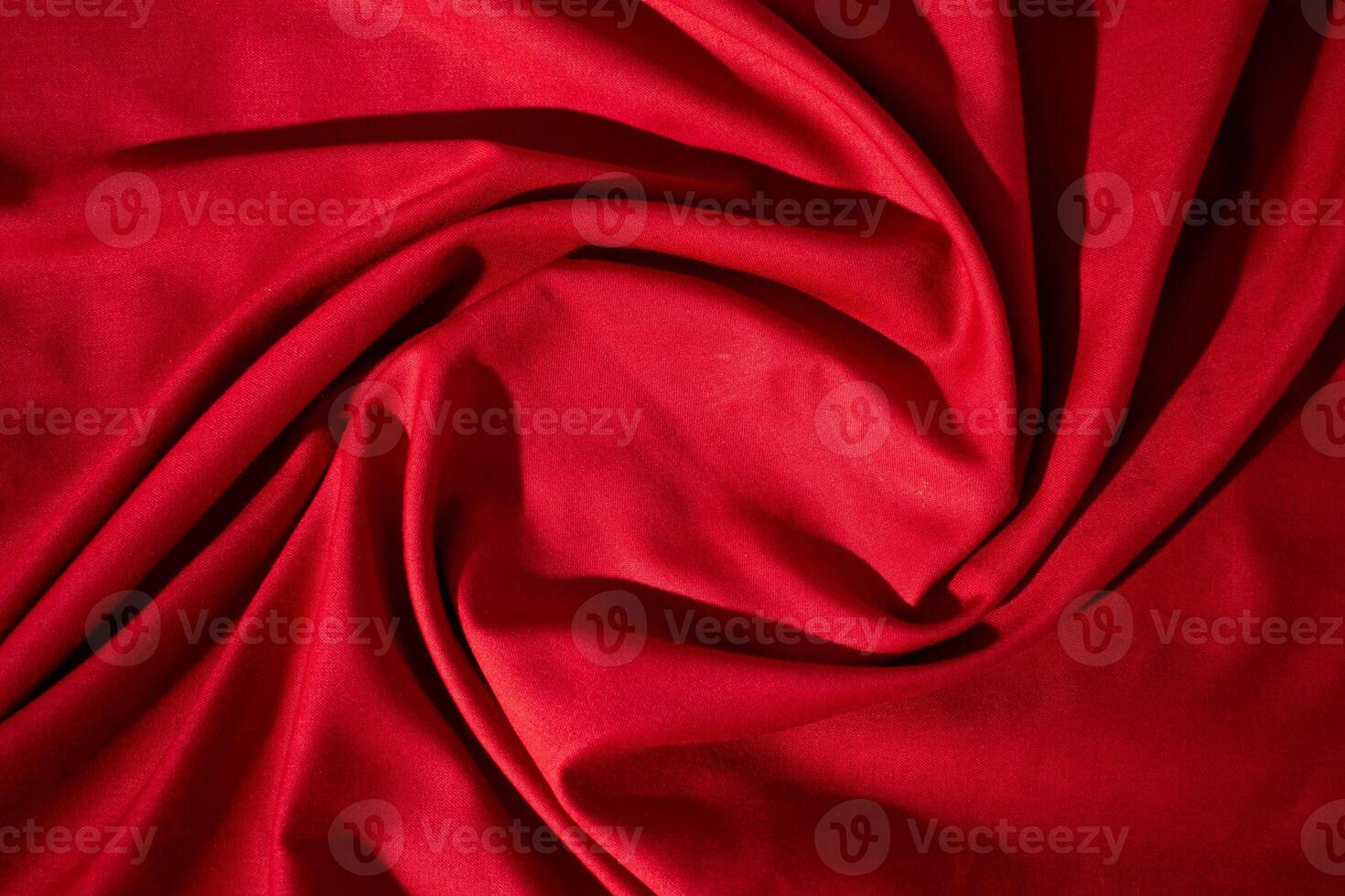 Red wavy spiral crumpled fabric texture with copy space. photo