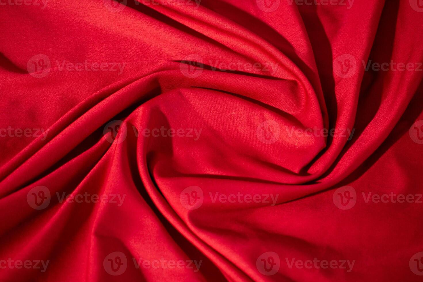 Red fabric wavy spiral crumpled fabric texture with copy space. photo