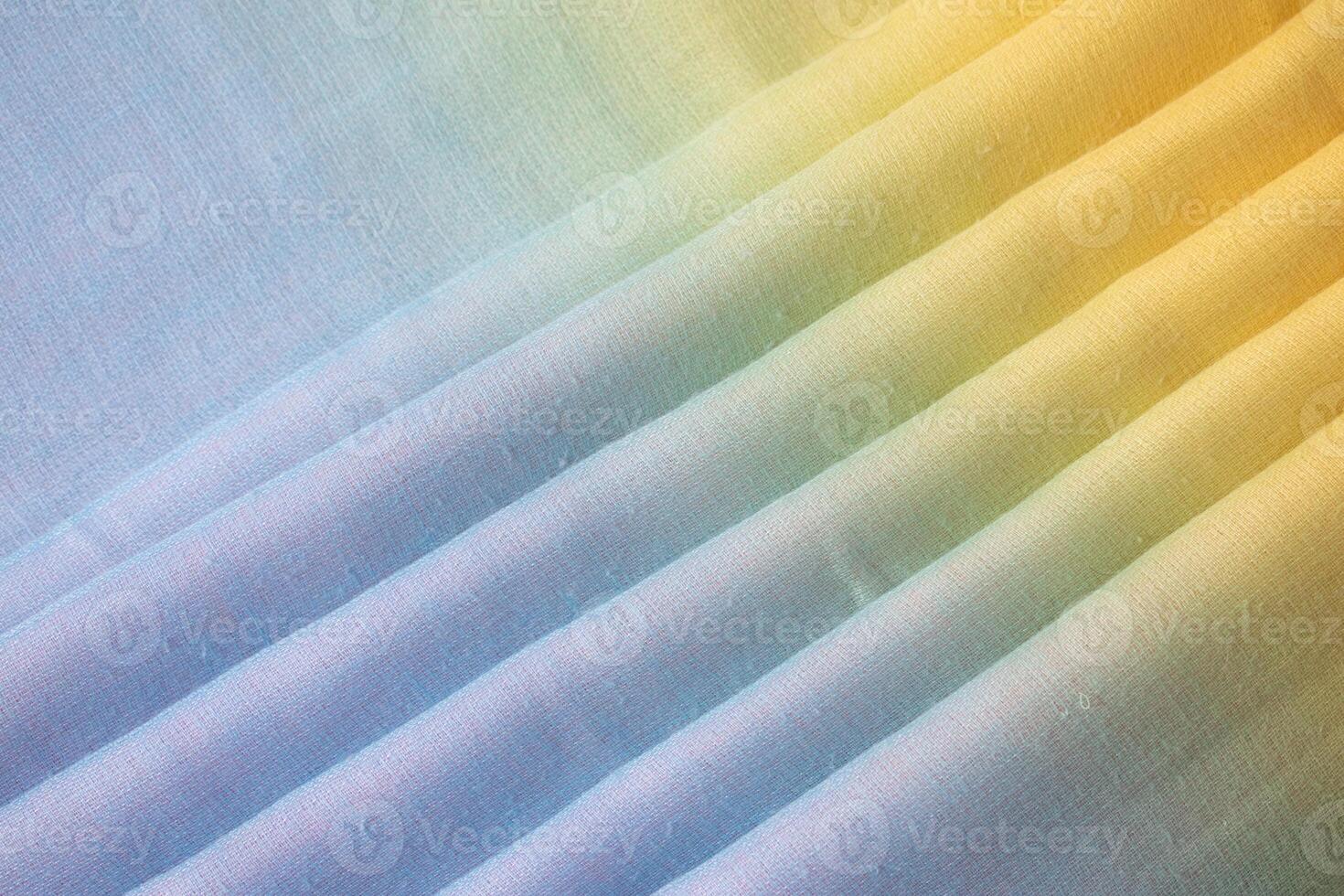 Gradient colorful rainbow folded fabric background texture. blue yellow and green. photo