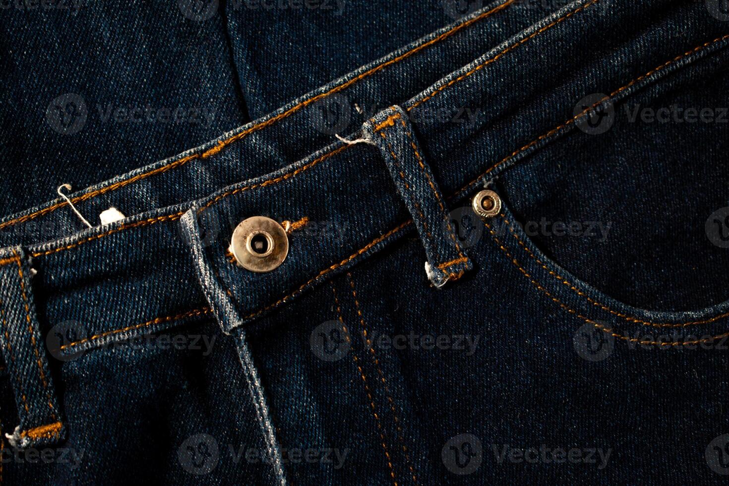 Close up gold and shiny button navy blue jeans fabric abstract background texture. photo