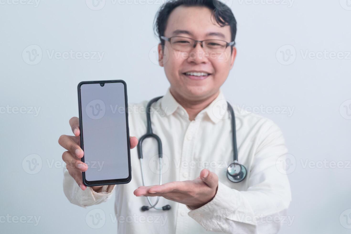 smiling Asian man doctor, male nurse presenting and showing phone isolated white background. photo