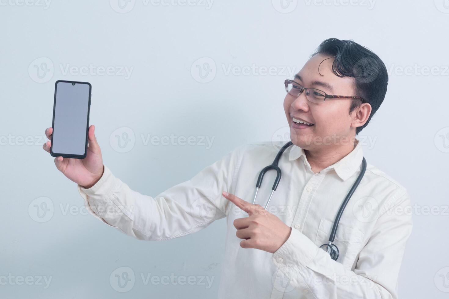 cheerful Asian man doctor, male nurse Pointing and showing phone isolated white background. photo
