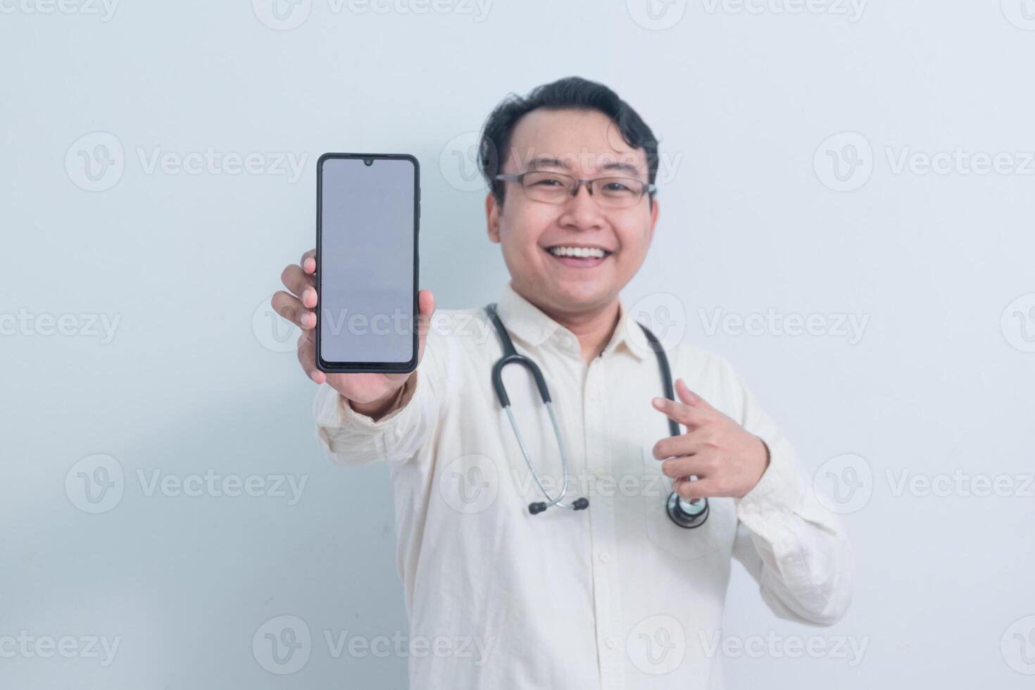 cheerful Asian man doctor, male nurse Pointing and showing phone isolated white photo