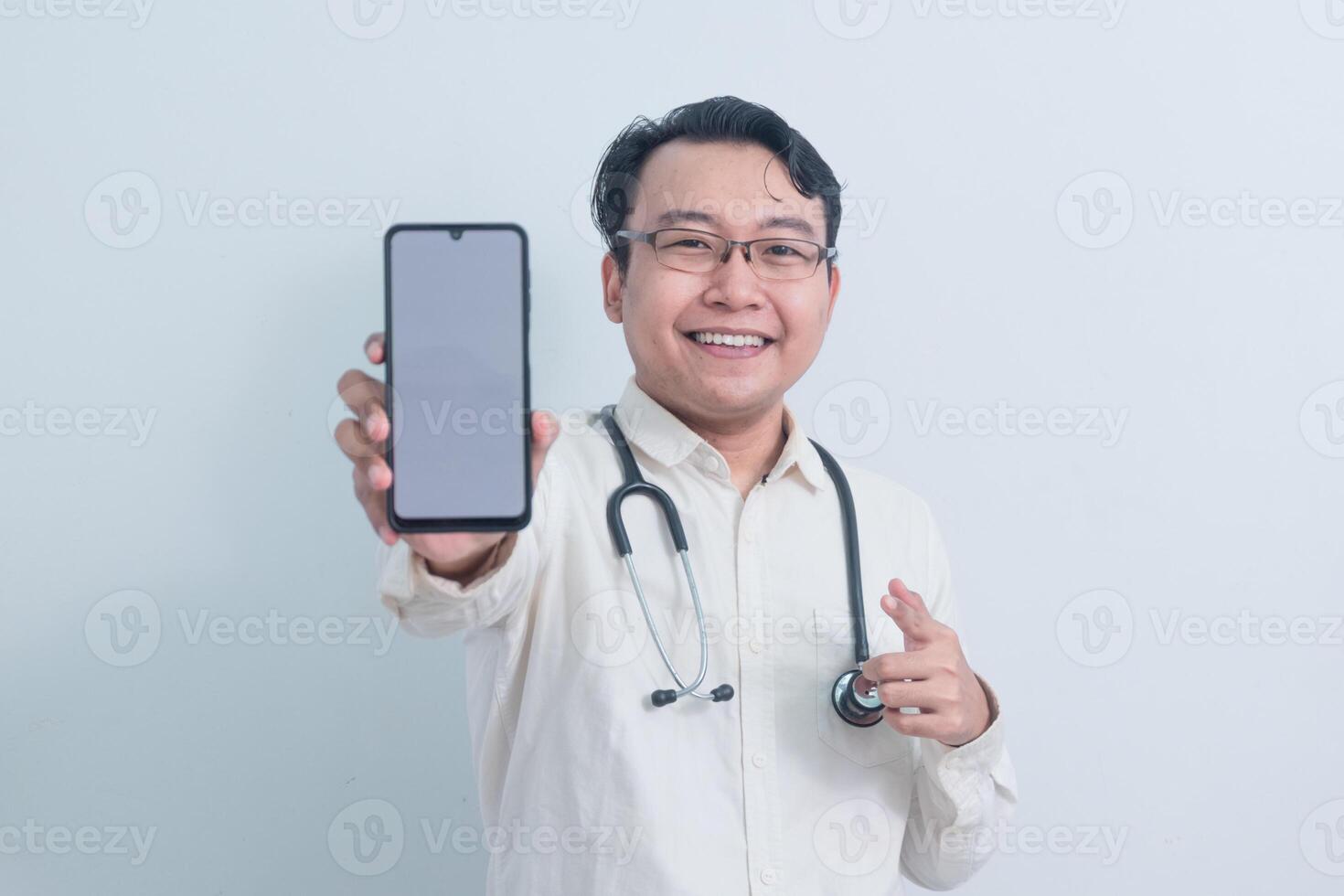 joyful Asian man doctor, male nurse Pointing and showing phone isolated white photo
