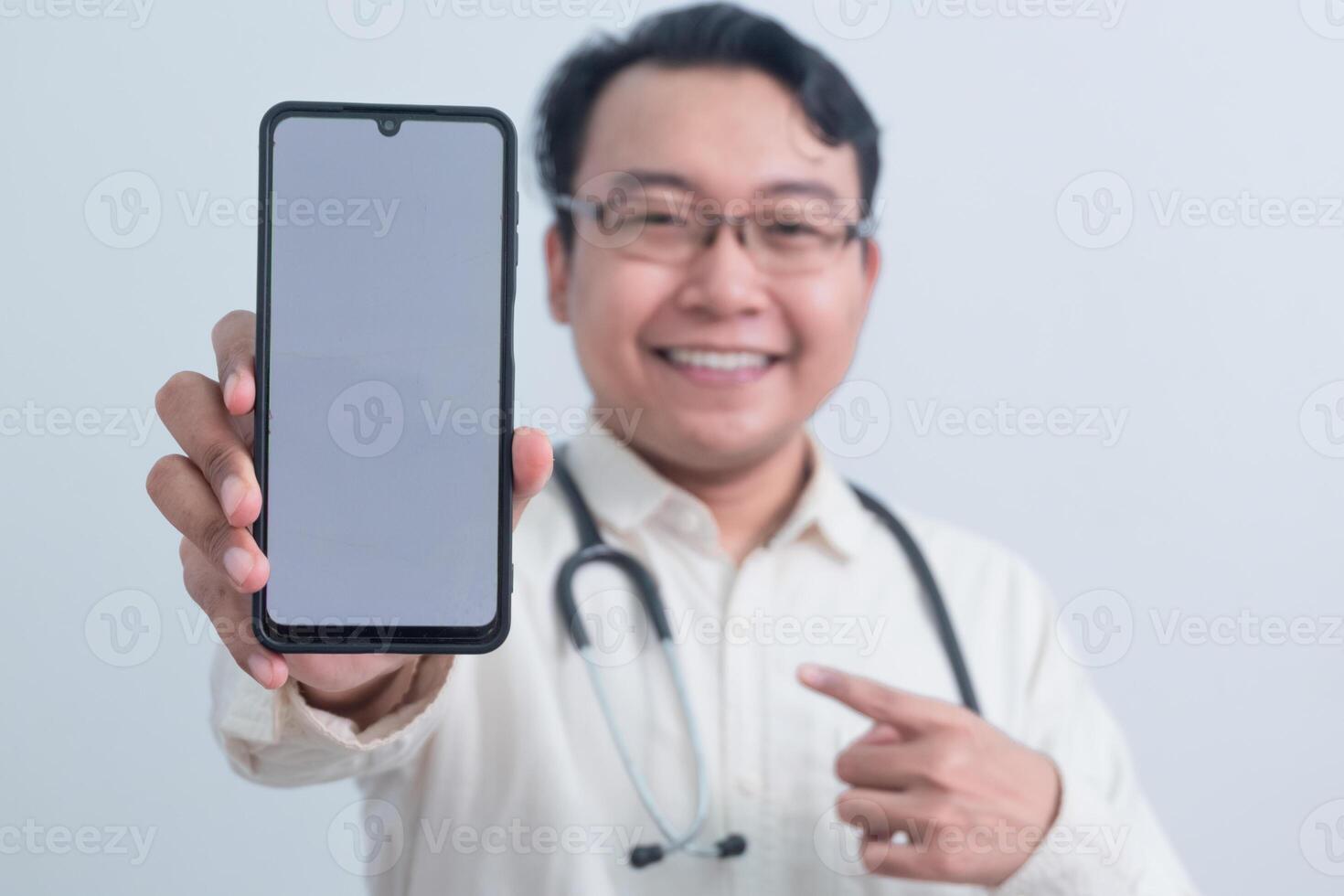 joyful Asian man doctor, male nurse Pointing and showing phone at the camera isolated white background. photo