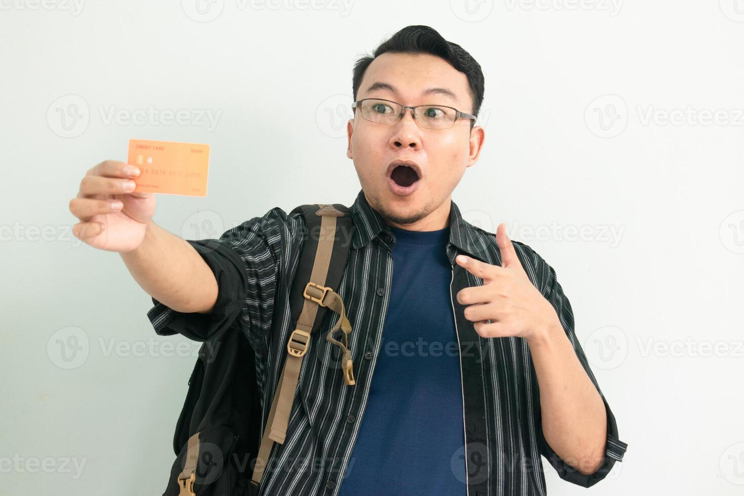 Delighted asian student hold and pointing credit card gesture. Banking, Financial isolated concept. photo