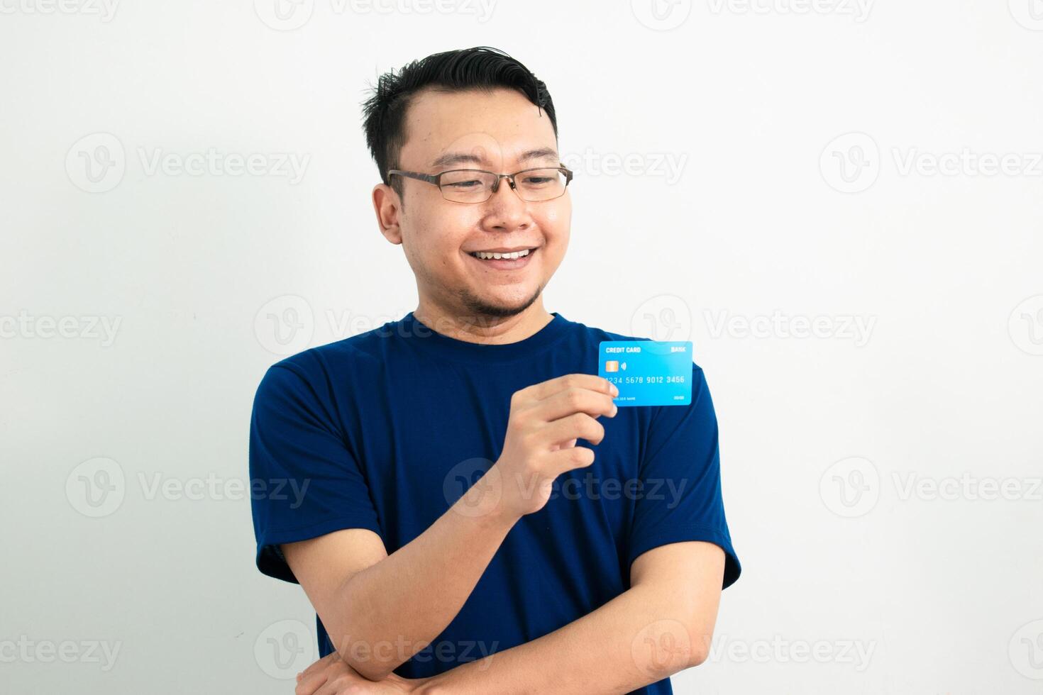 Joyful asian man hold credit card. Banking, Financial isolated white background, blue concept. photo