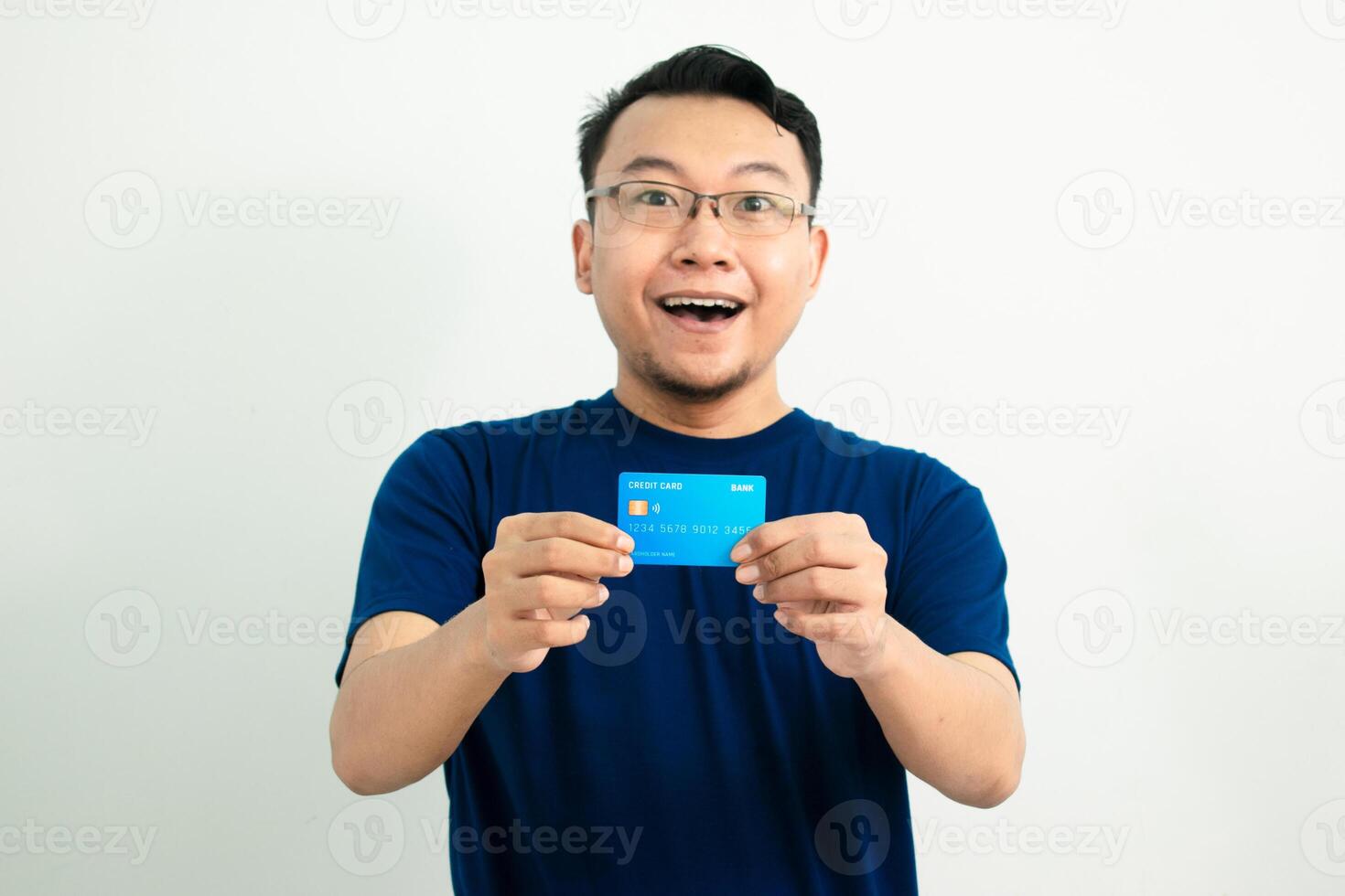 Delighted asian man wear blue tshirt hold credit card. Banking, Financial isolated background, blue concept. photo
