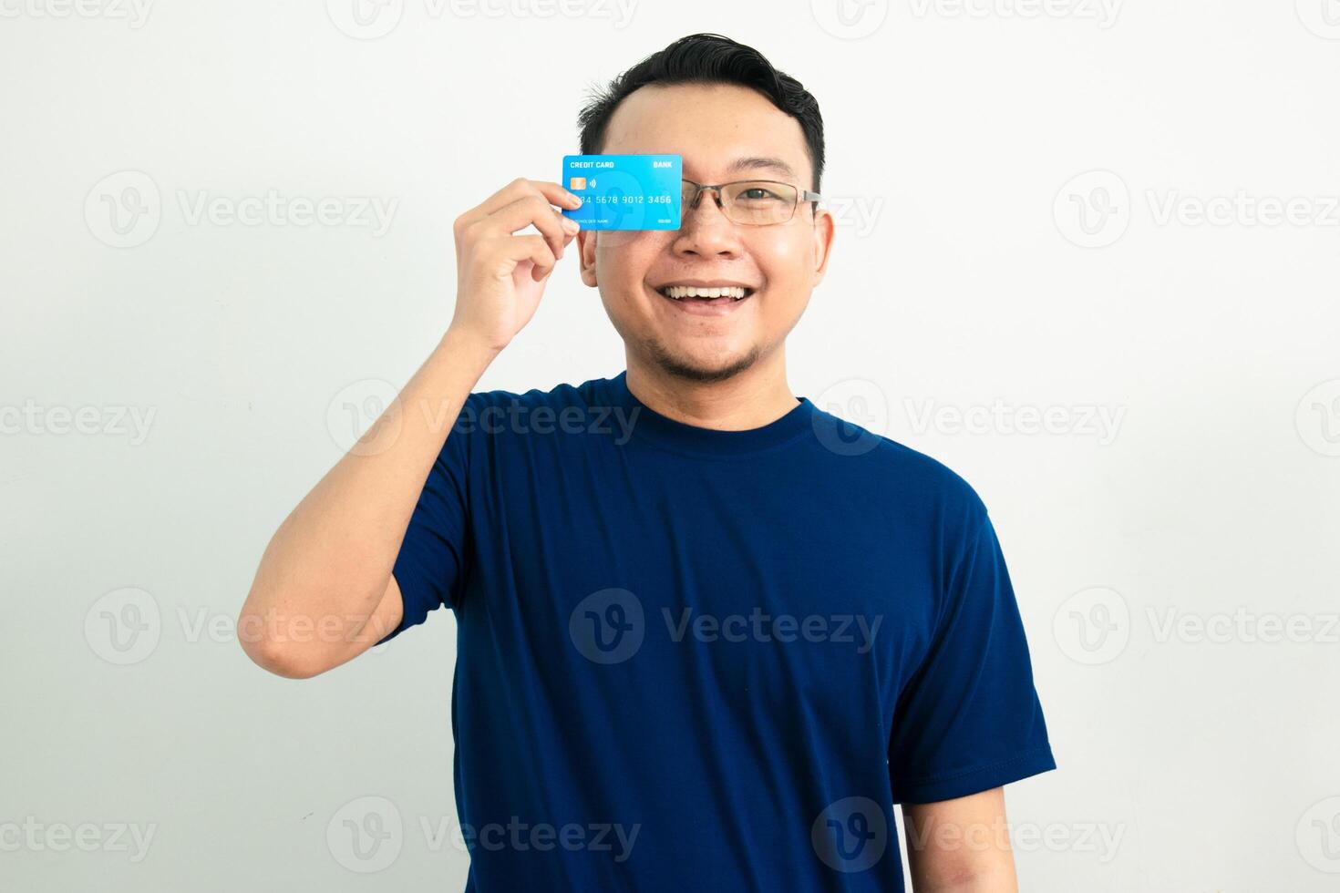 Happy asian man hold credit card over head. Banking, Financial isolated background, blue color concept. photo