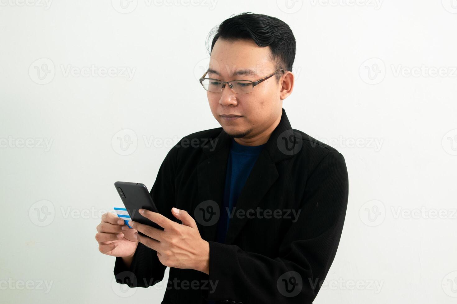 Happy Asian businessman doing transaction with credit card and phone. Banking, Financial and technology isolated concept. photo