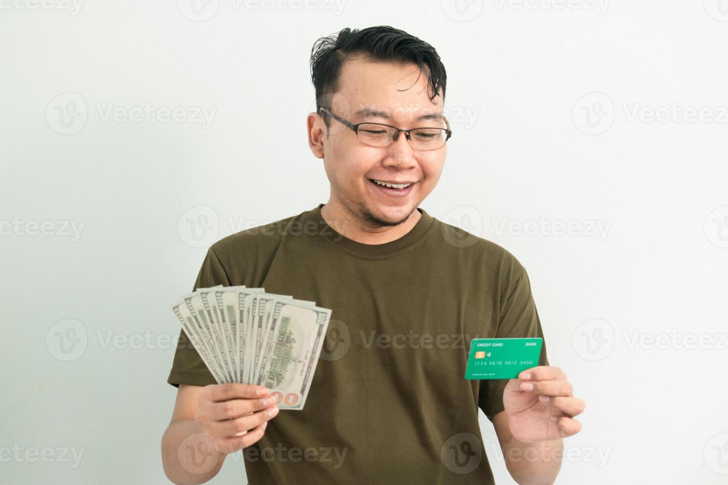 Cheerful asian man hold credit card and money. Banking, Financial isolated background, green color concept. photo