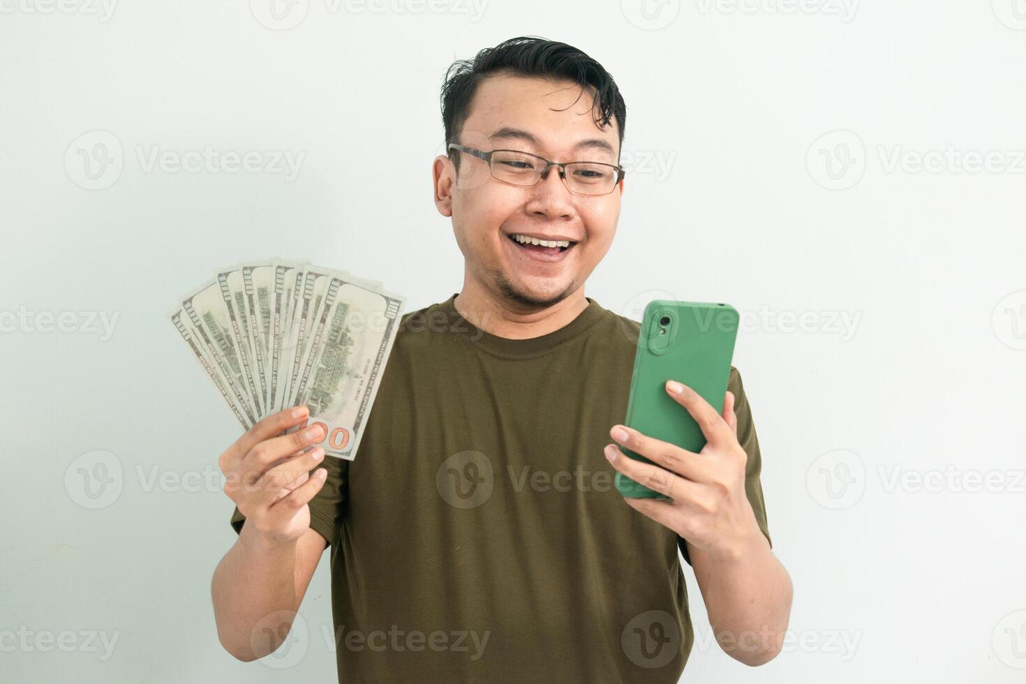 Happy asian man hold Money and phone. Banking, Financial and technology isolated background, green color concept. photo