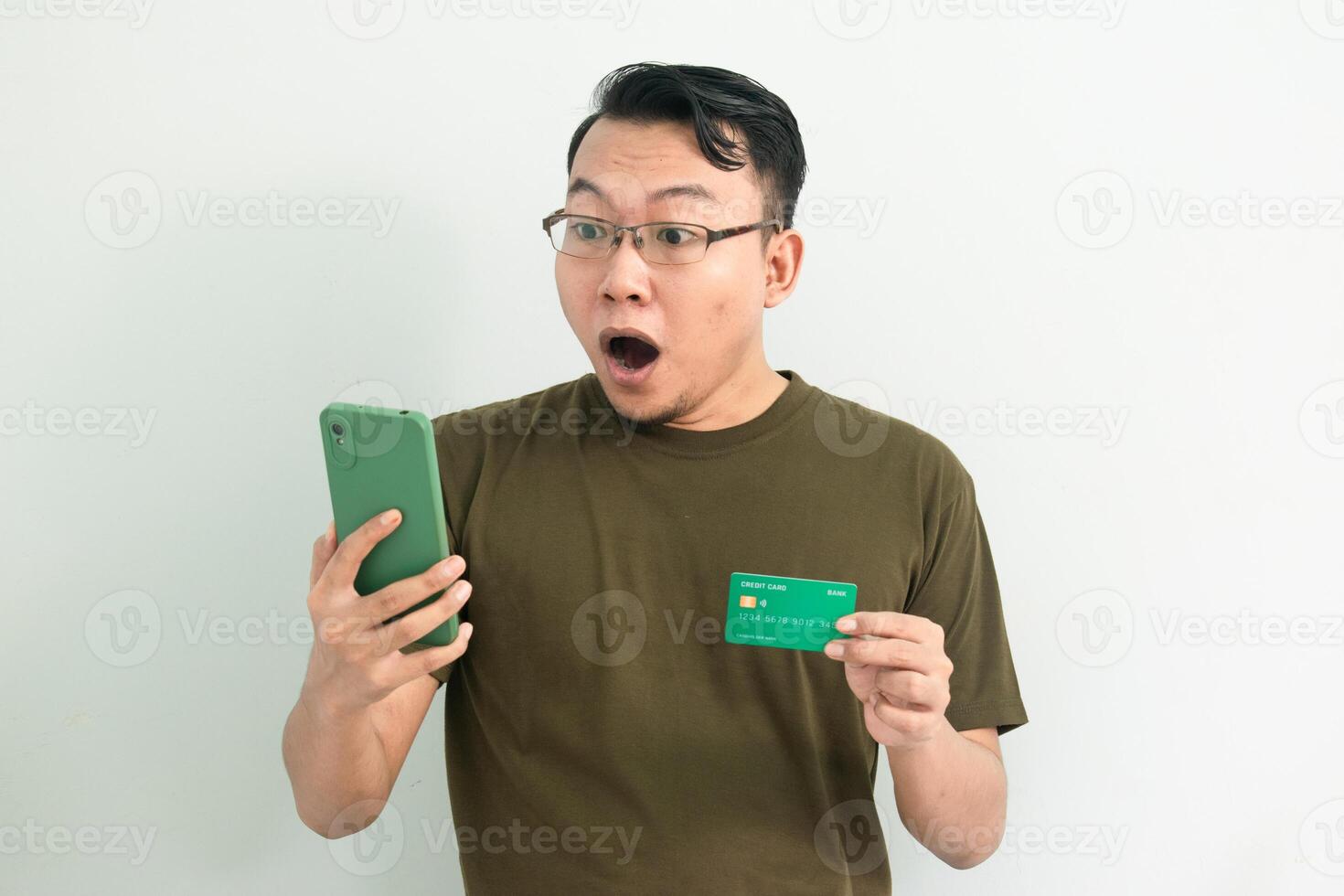 Amaze Asian man doing transaction with credit card and phone. Banking, Financial and technology isolated background, green color concept. photo