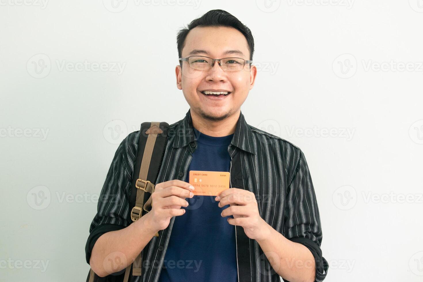 Delighted Asian Student hold credit card over head. School, Banking, Financial isolated background, blue color concept. photo