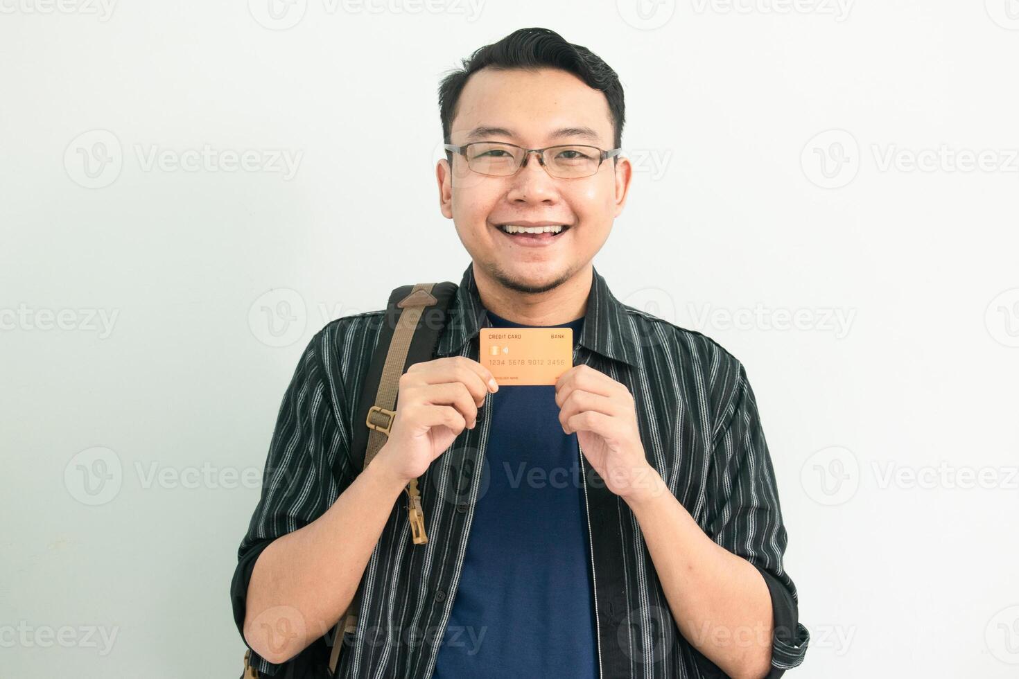 Happy Asian Student hold credit card. School, Banking, Financial isolated white background, blue concept. photo