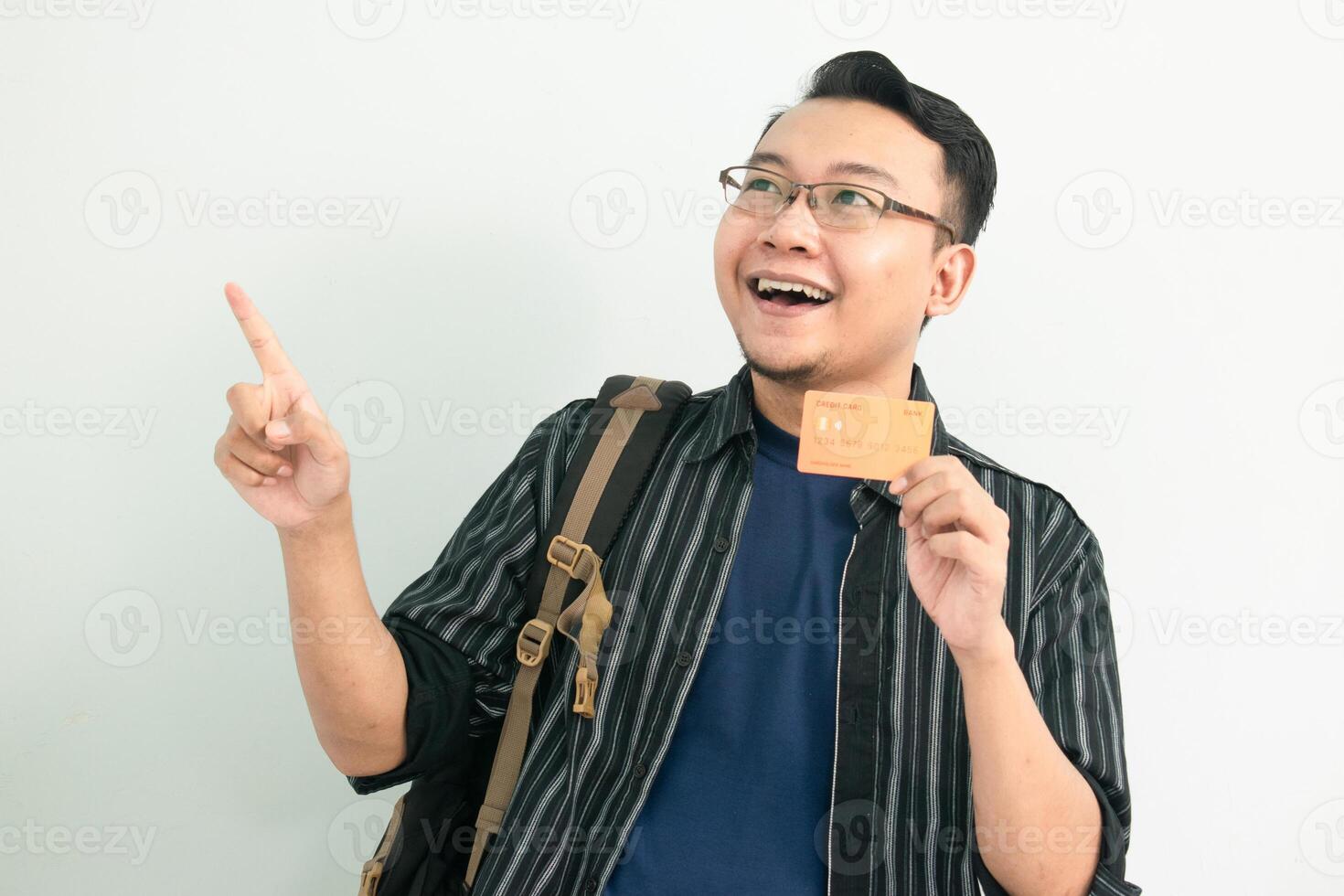 Joyful asian student hold credit card with pointing gesture. Banking, Financial isolated concept. photo