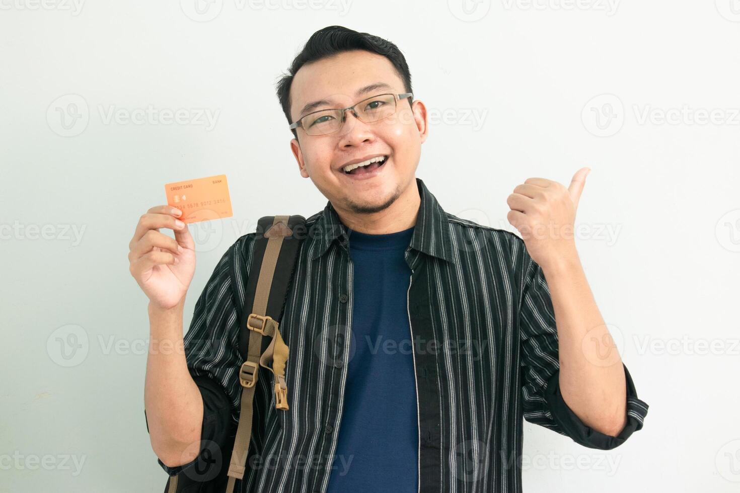 Happy asian student hold credit card with pointing gesture. Banking, Financial isolated concept. photo