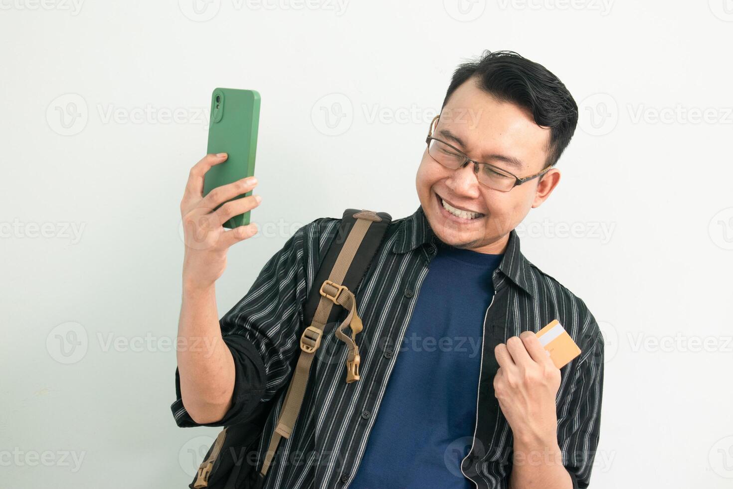 Happy asian Student hold credit card and phone with celebrating pose. Banking, Financial and technology isolated background photo